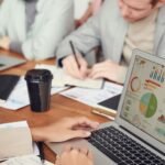 Business owner meeting professionals with charts and a laptop to choose a valuation expert