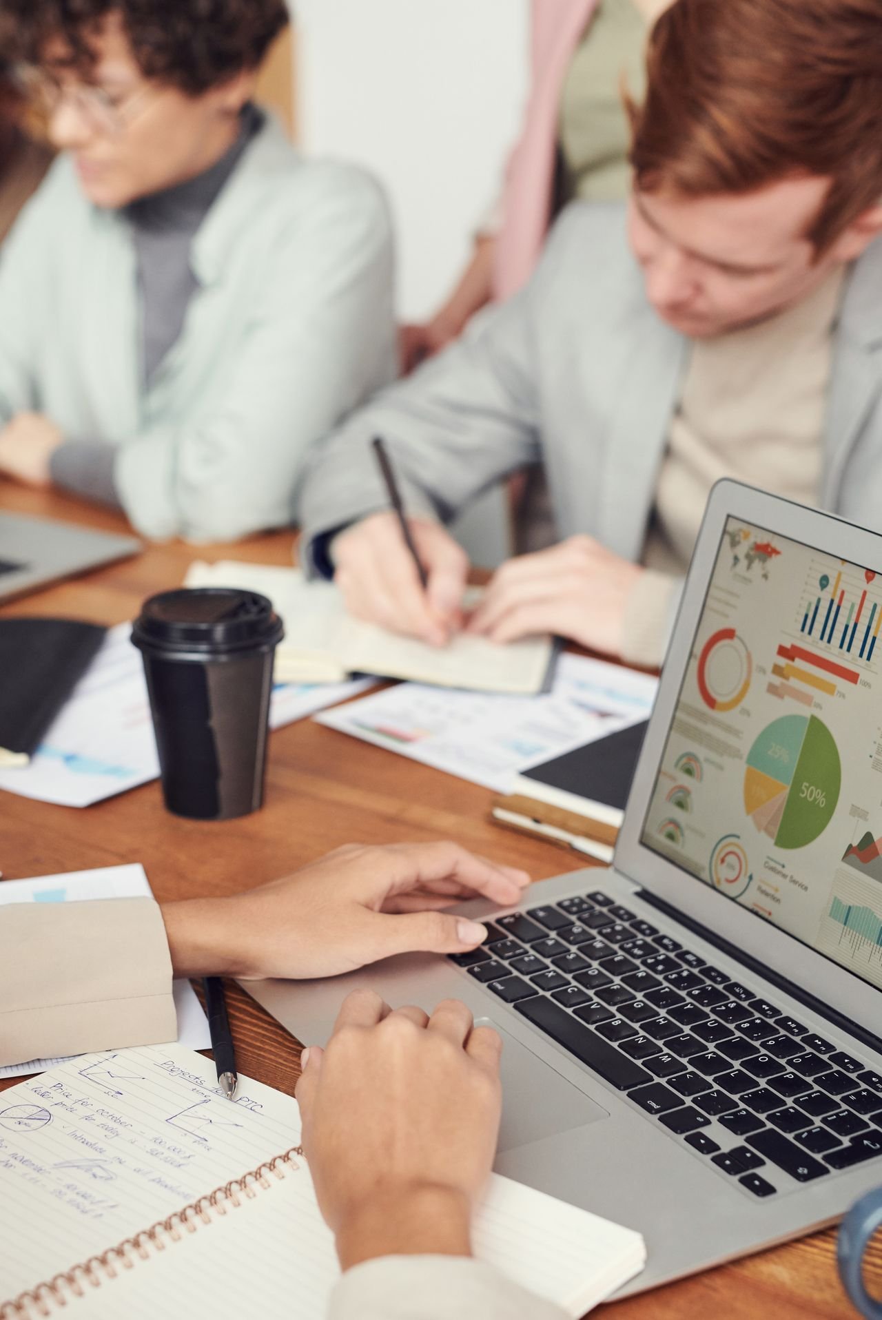Business owner meeting professionals with charts and a laptop to choose a valuation expert