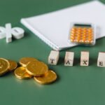 Coins and calculator beside the word taxes, for a nonprofit reinstating tax-exempt status