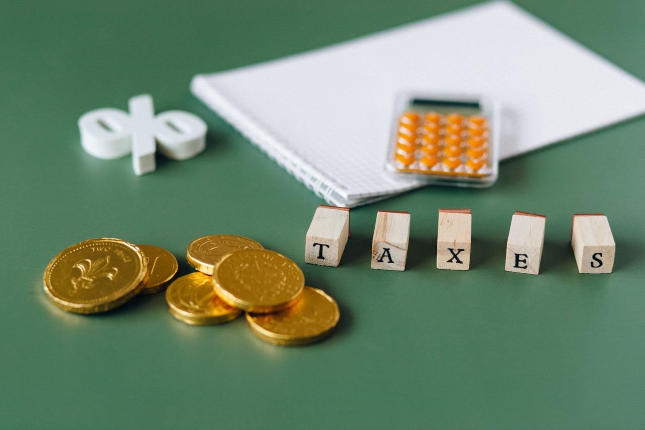 Coins and calculator beside the word taxes, for a nonprofit reinstating tax-exempt status