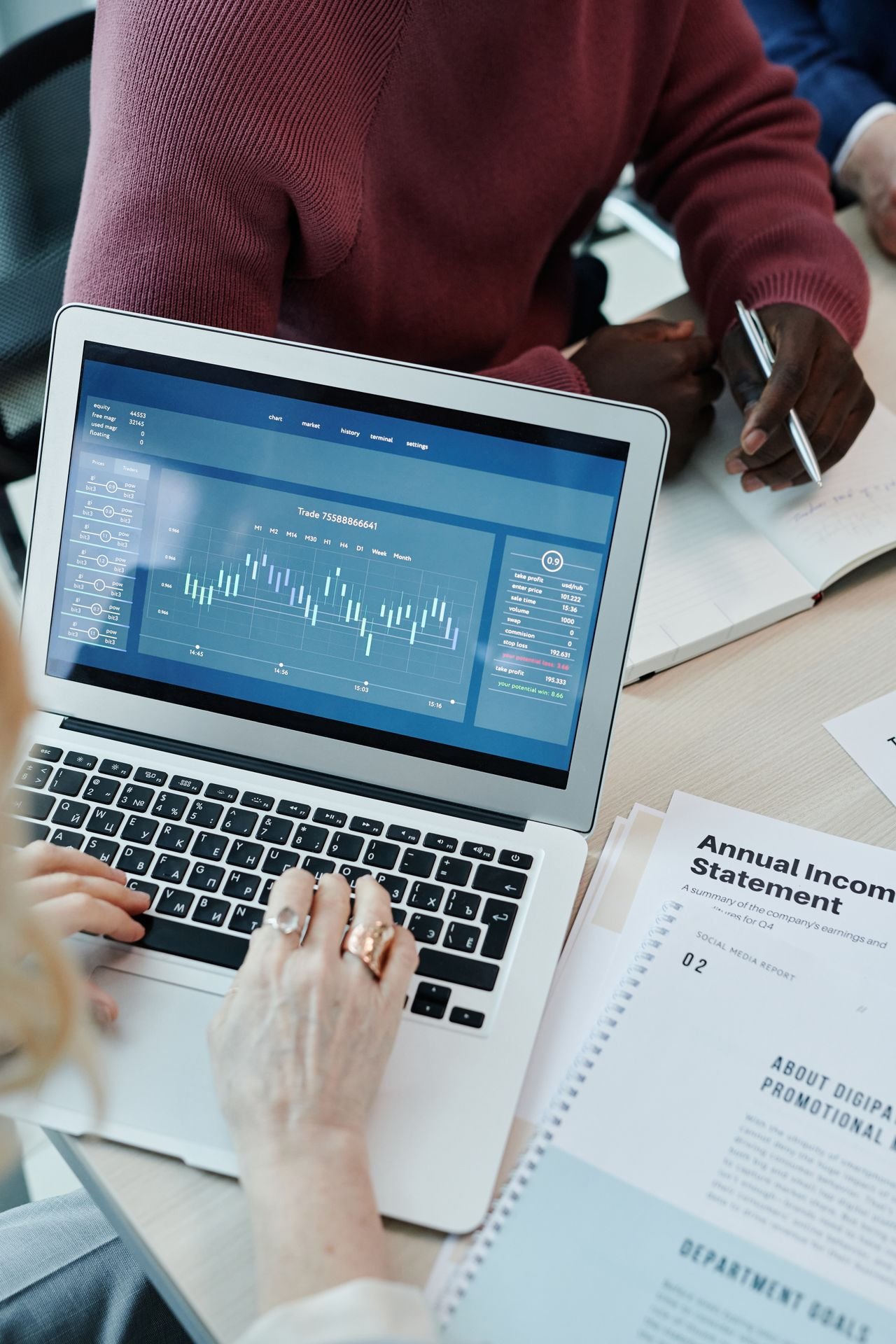 Deal team reviewing a working capital schedule and financial papers during a business sale