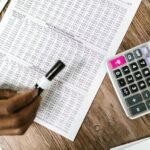 Financial statements and a calculator used to calculate normalization adjustments and add-backs