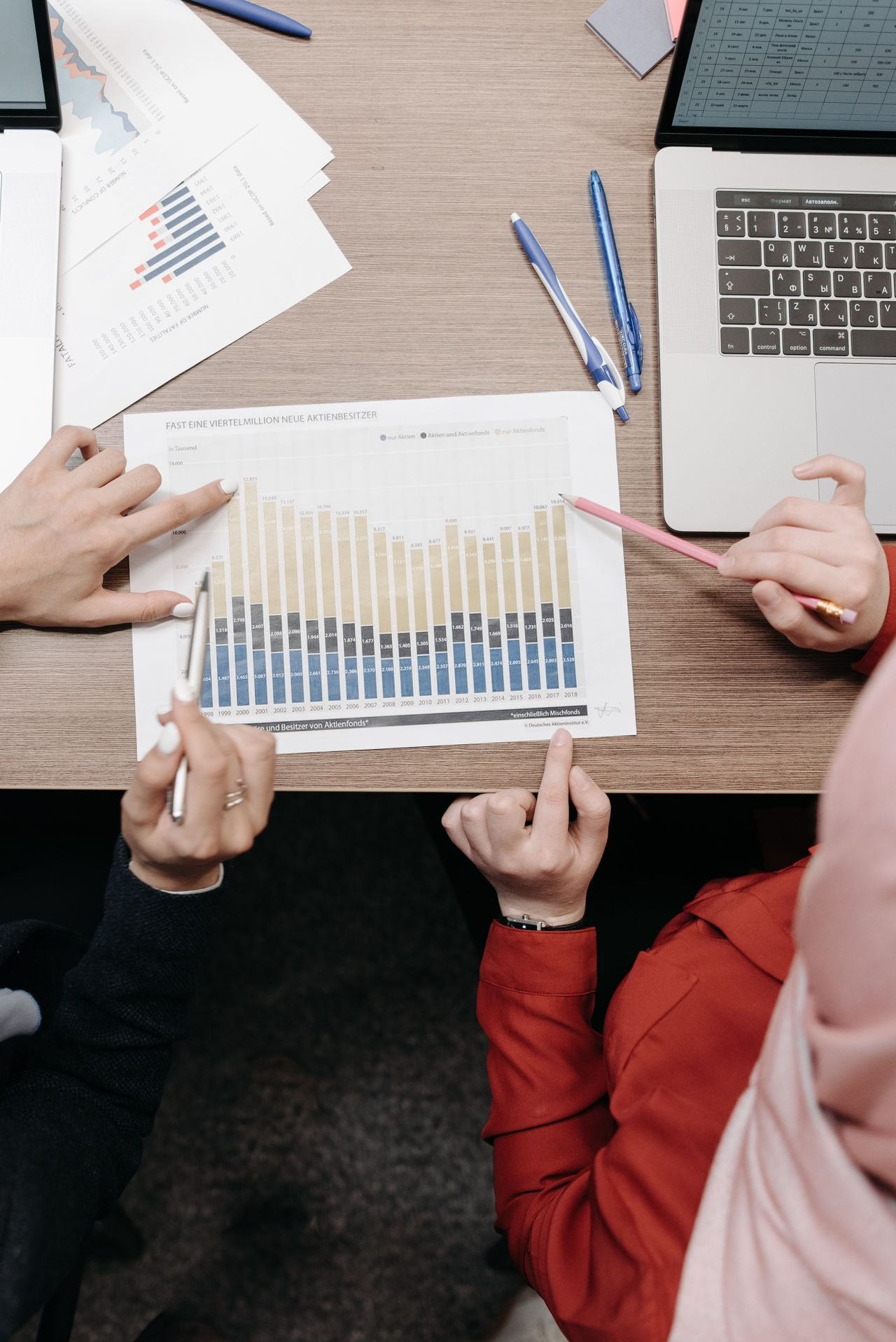 Controller and colleague reviewing financial graphs and documents for a goodwill impairment analysis